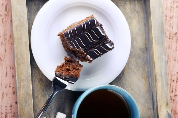 Mesa servida con una taza de té y pastel de chocolate sobre fondo de madera —  Fotos de Stock