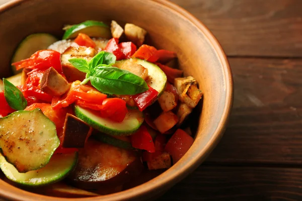 Smakrik vegetarisk ratatouille av aubergine, squash, tomater i skål på träbord bakgrund — Stockfoto
