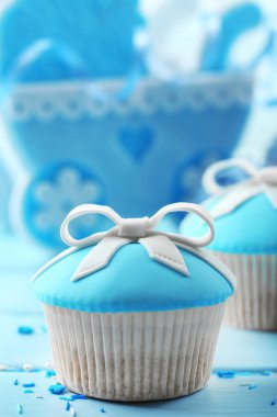 Renk ahşap arka plan üzerinde yay ve bebek ayakkabı ile lezzetli kek