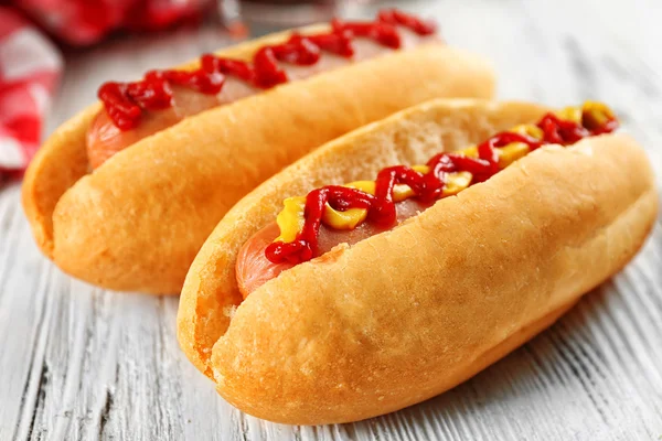 Delicious hot-dogs με μάρκες σε άσπρο φόντο ξύλινη — Φωτογραφία Αρχείου