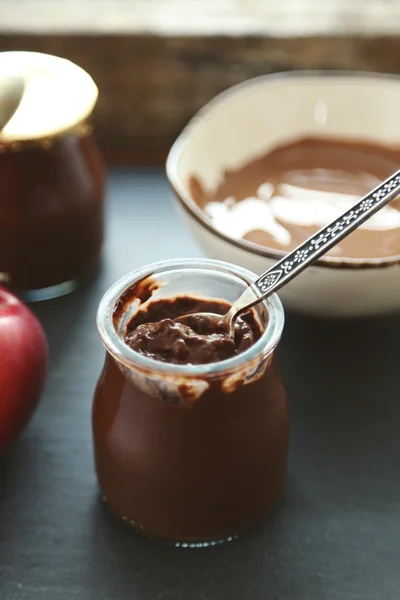 Chocoladedessert in kleine glazen potten en stukjes op plaat, op houten achtergrond — Stockfoto