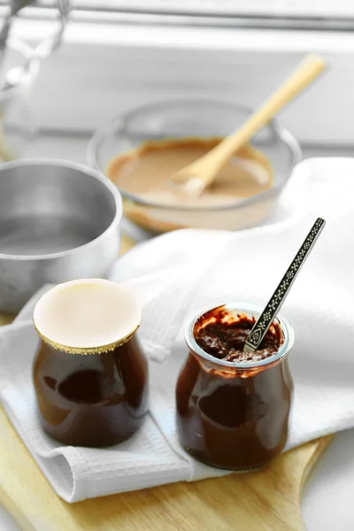 Chocolate dessert in a small glass jars on light wooden background — Stock Photo, Image