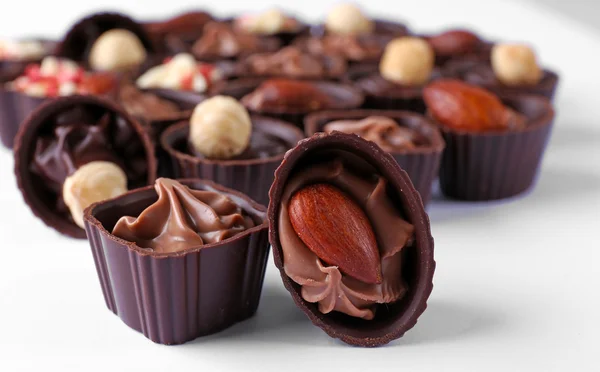 Deliciosos caramelos de chocolate sobre fondo blanco, de cerca — Foto de Stock