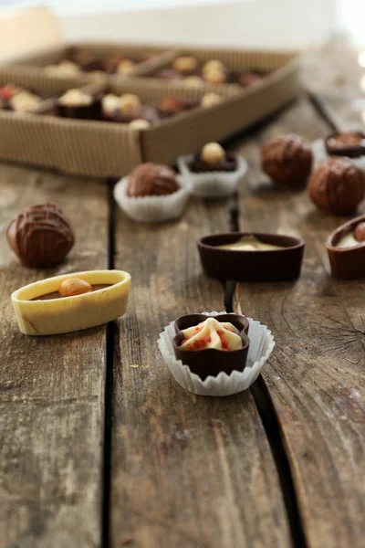 Diferentes dulces de chocolate sabrosos en la mesa de madera, de cerca — Foto de Stock