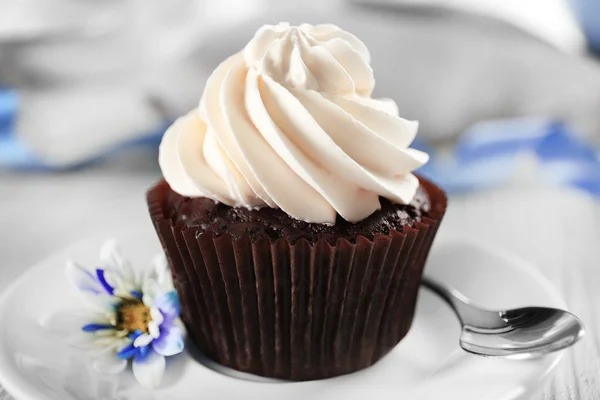 Heerlijke chocolade cupcake met crème op versierde houten tafel, close-up — Stockfoto