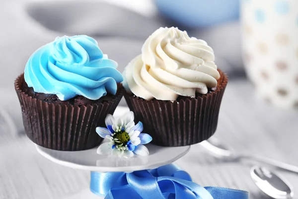 Bolinhos de chocolate com creme colorido na mesa decorada, close-up — Fotografia de Stock