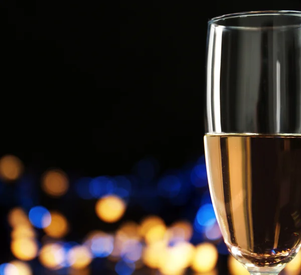 Een glas champagne met bokeh op donkere achtergrond — Stockfoto