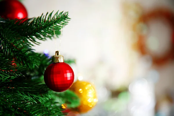 Bauble rosso di Natale su un abete su sfondo sfocato — Foto Stock