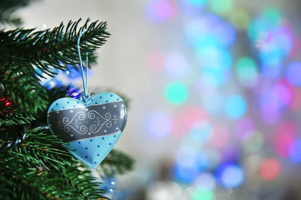 Kerstmis blauw hart op een spar boom over wazig achtergrond, close-up — Stockfoto