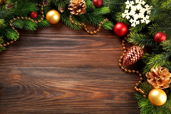 Fir kerstboom takken met speelgoed op houten tafel — Stockfoto