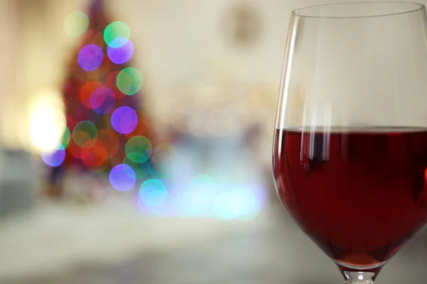 Glas rött vin på suddig bakgrund — Stockfoto