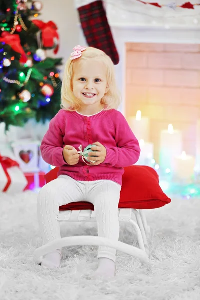 Menina engraçada na sala de estar e árvore de Natal no fundo — Fotografia de Stock