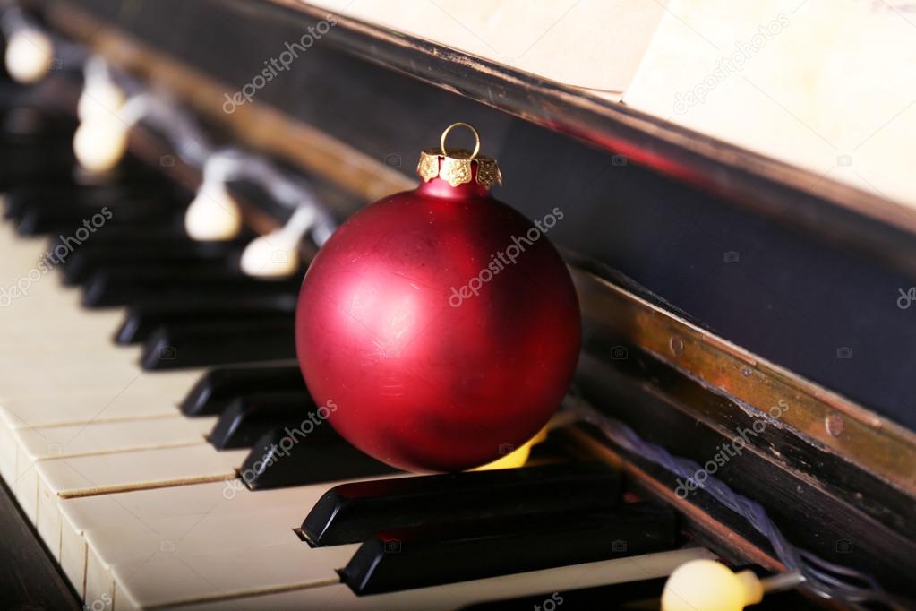 Piano keys decorated with decoration lights and red ball, close up