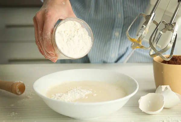 Woman is adding flour to the mixture — Stock Photo, Image