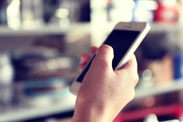 Frau hält Smartphone im Haus — Stockfoto