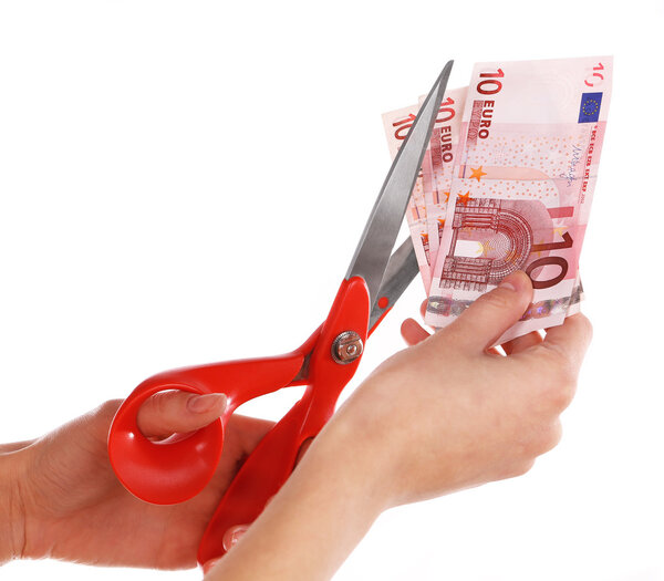 Hands with scissors cutting Euro banknotes, isolated on white