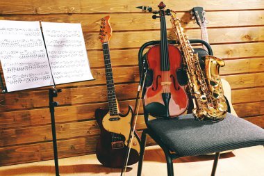 Müzik aletleri üzerinde ahşap arka plan karşı bir sandalye ve Not tutucu