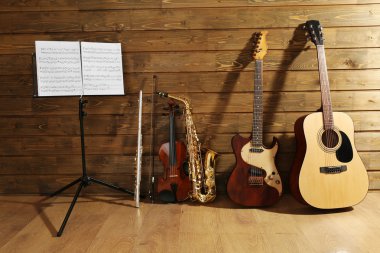 Not tutucu karşı ahşap arka plan üzerinde müzik aletleri