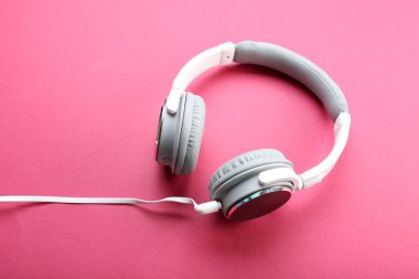 Pembe bir arka plan üzerinde beyaz ve gri kulaklık