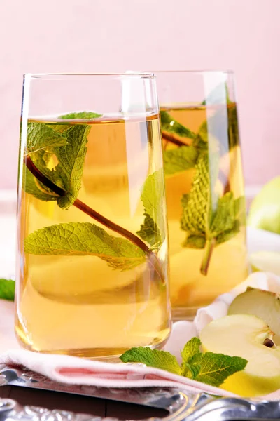 Copos de suco de maçã com frutas e hortelã fresca na mesa de perto — Fotografia de Stock