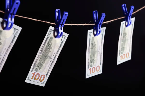 Concept of money laundering - one hundred bills hanging on a cord against grey background — Stock Photo, Image