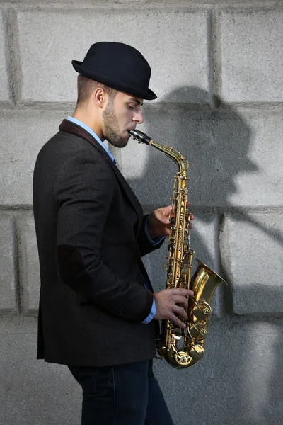 Young man playing on saxophone