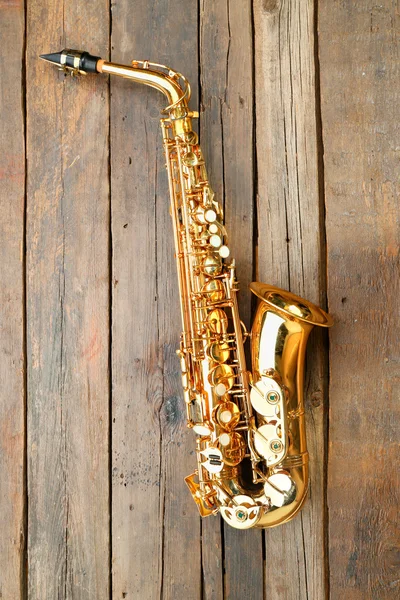 Beau saxophone doré sur fond bois — Photo