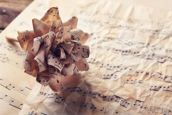 Hermosa rosa hecha en papel sobre notas musicales — Foto de Stock