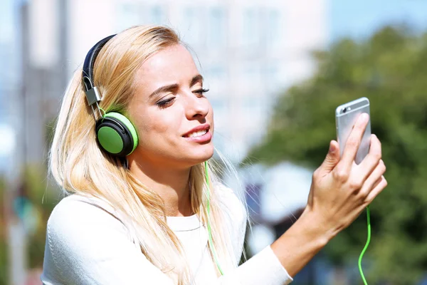 Ung kvinna lyssna på musik utanför — Stockfoto