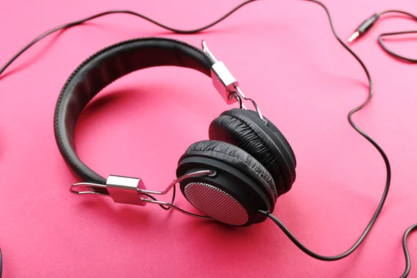 Auriculares negros sobre fondo rosa — Foto de Stock