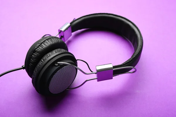 Auriculares negros sobre fondo morado — Foto de Stock