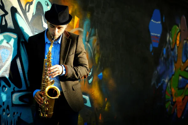 Junger Mann spielt auf Saxofon Stockbild