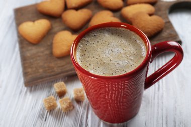 Kırmızı fincan sıcak kakao ve kalp şeklinde kurabiye