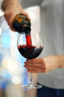 Genç kadın kırmızı şarap cam içine dökme