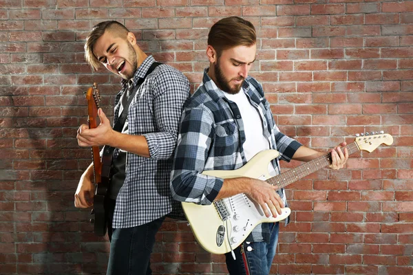 Hombres jóvenes tocando guitarras — Foto de Stock