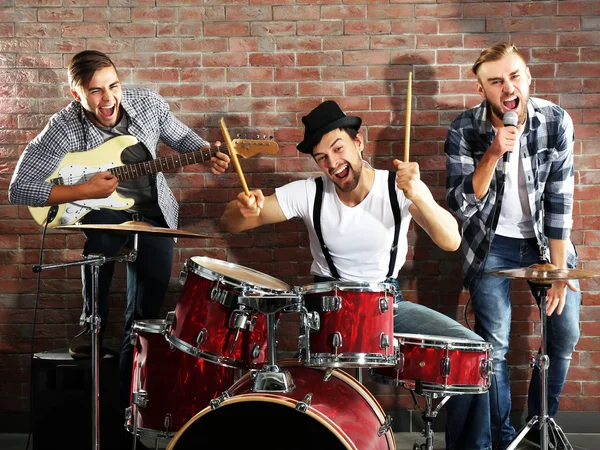 Музыканты играют на барабанах и гитаре — стоковое фото