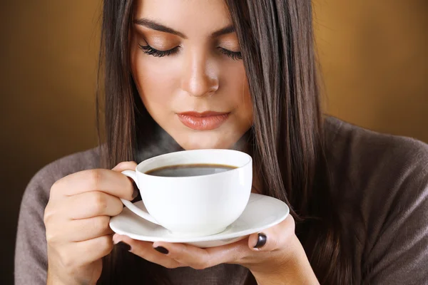 Woman holds cup of coffee and saucer in hands, close up — Stock Photo, Image