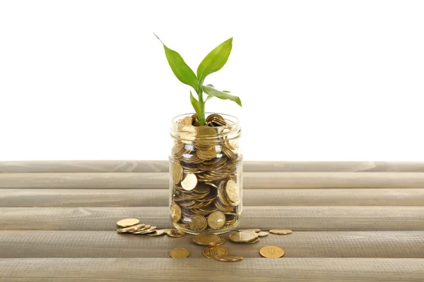 Geld en groeiende stronk in glazen pot op houten tafel — Stockfoto