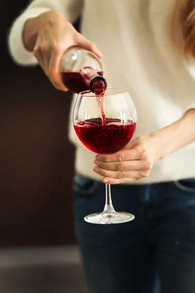 Junge Frau gießt rosa Wein in Glas auf verschwommenem Hintergrund — Stockfoto