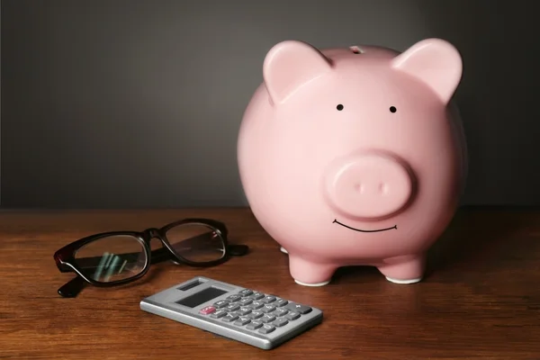 Banco porquinho e calculadora na mesa — Fotografia de Stock