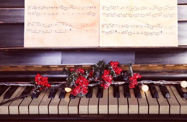Piano keys decorated with Christmas decorations, close up — Stock Photo, Image