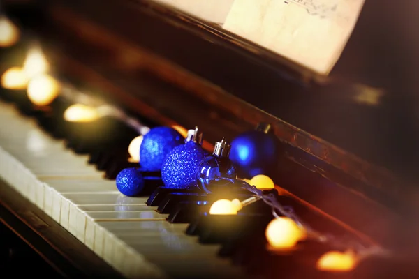 Clés de piano décorées avec des lumières décoratives et des boules, gros plan — Photo