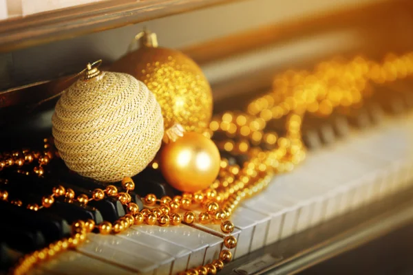Llaves de piano decoradas con decoraciones navideñas doradas, de cerca — Foto de Stock