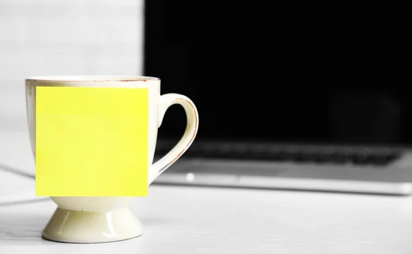 Yellow adhesive note on coffee cup — Stock Photo, Image