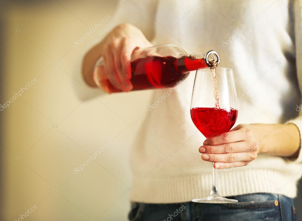 woman pouring pink wine into glass