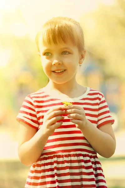 Маленькая счастливая девочка играет в парке — стоковое фото