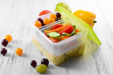 Lezzetli yemek plastik kaplarda ahşap masa yakın çekim