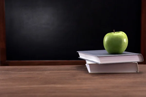 Apfel und Bücher auf dem Schreibtisch — Stockfoto