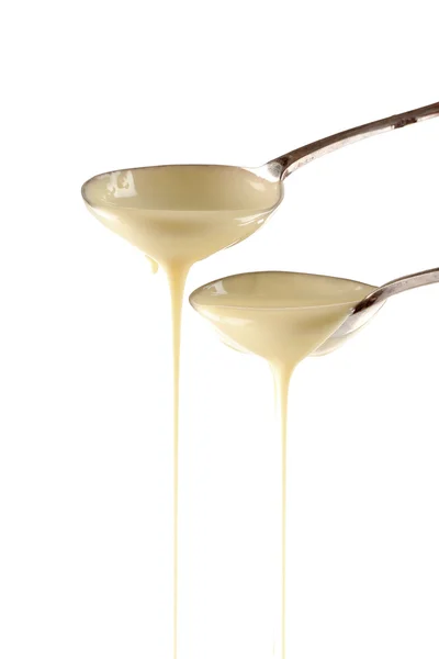 Lapte condensat turnat din linguri — Fotografie, imagine de stoc