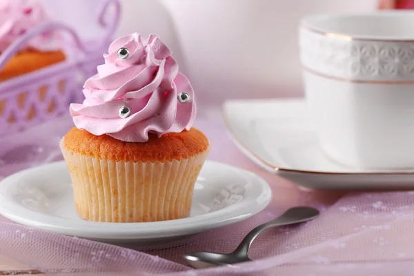 Sabroso cupcake en platillo, sobre fondo claro —  Fotos de Stock